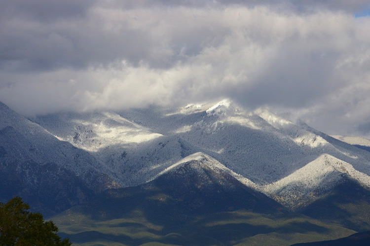 Lifting clouds reveal fresh snow on Taos Mountain.