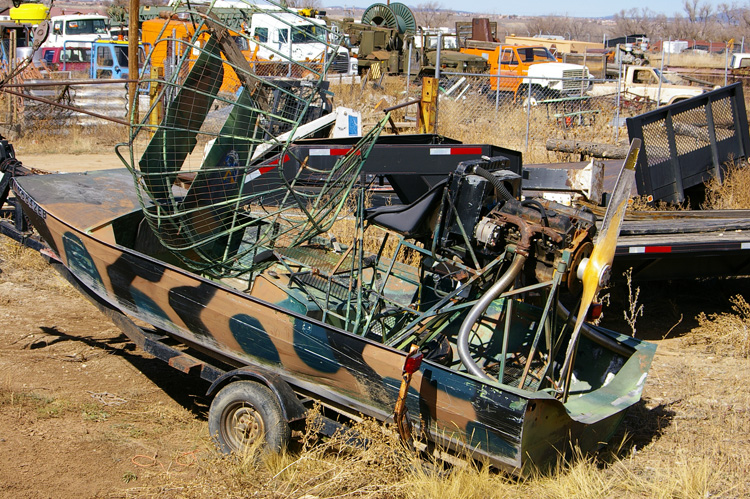 A battered old air boat rusting in the weeds behind the local WalMart in Taos, New Mexico.