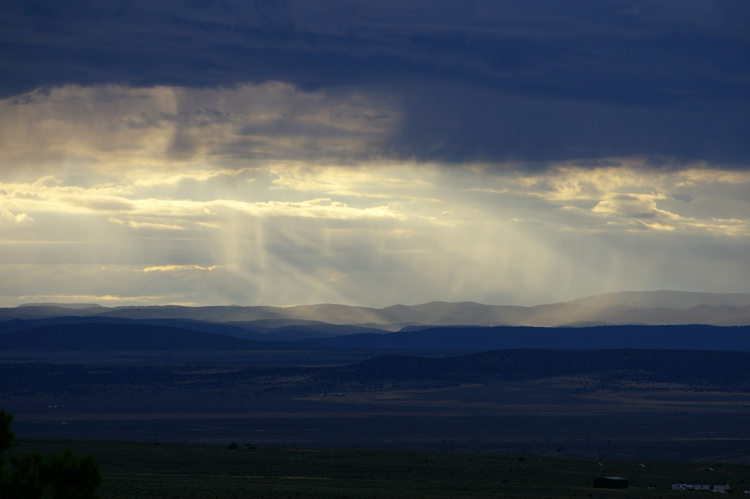 Late evening rain backlit by the setting sun in Taos, New Mexico